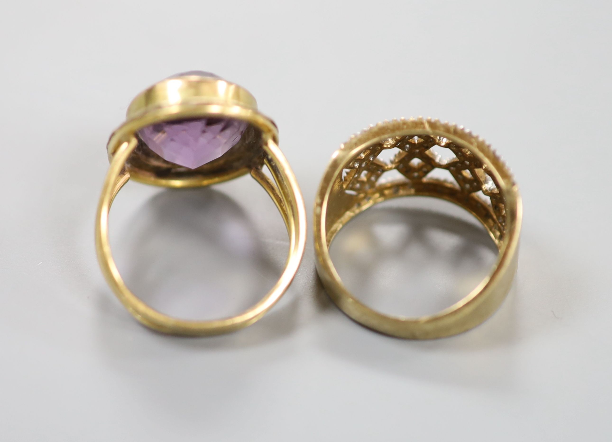 A modern pierced 9ct gold and diamond chip set dress ring, size P, gross 4.5 grams and a yellow metal and amethyst set oval dress ring, size N, gross 7.2 grams.